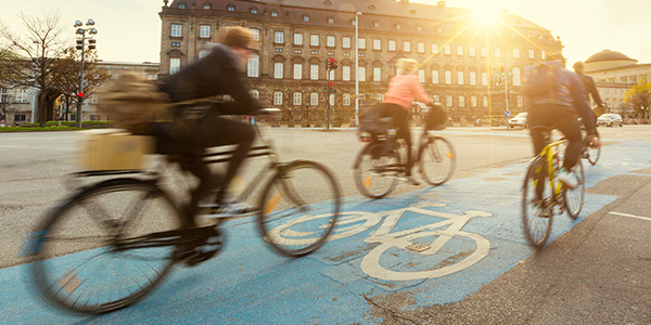 Vier fietsende mensen op een fietspad bij ondergaande zon