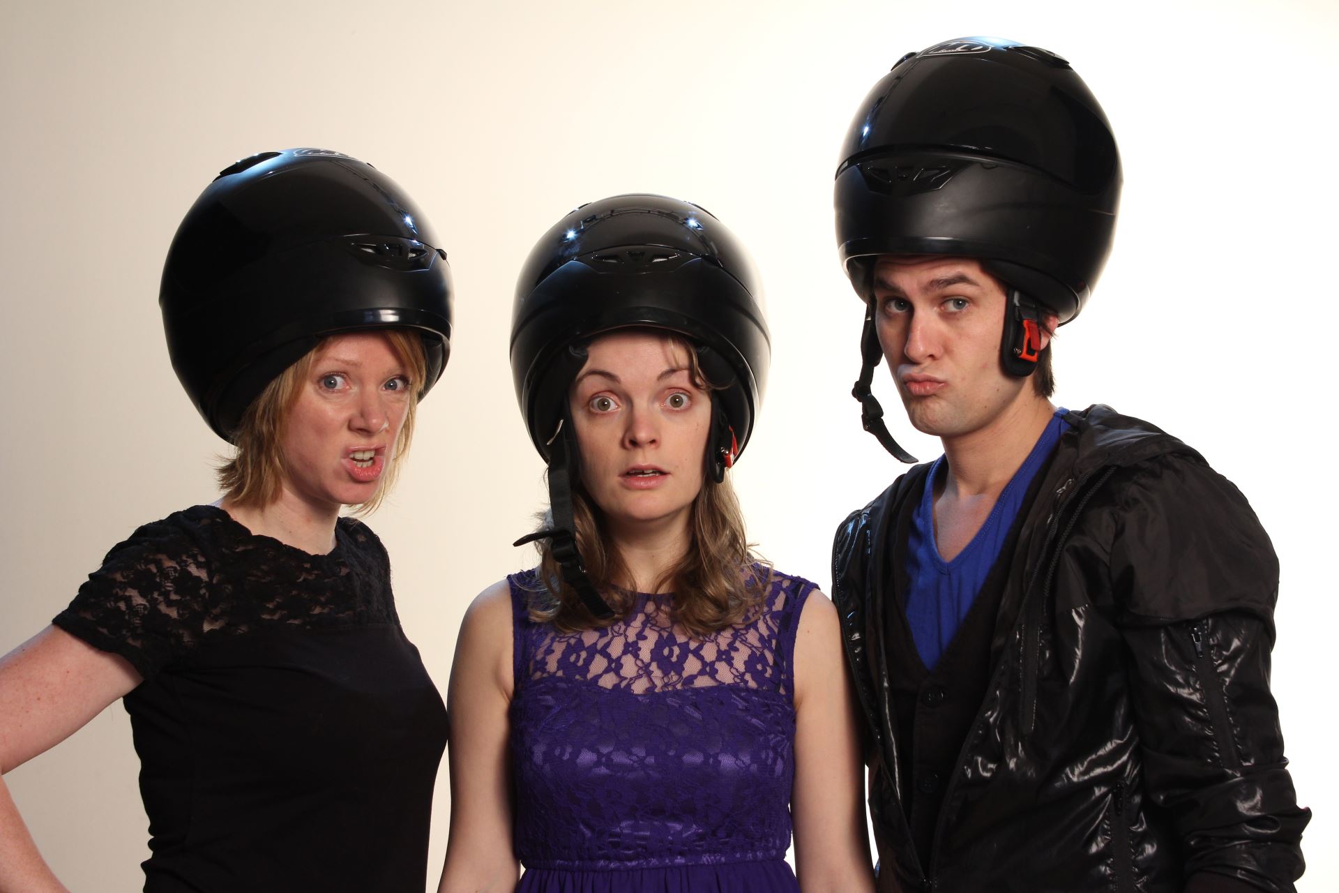 Twee vrouwen en een man met een zwarte helm boven op hun hoofd waarbij gezicht zichtbaar is.